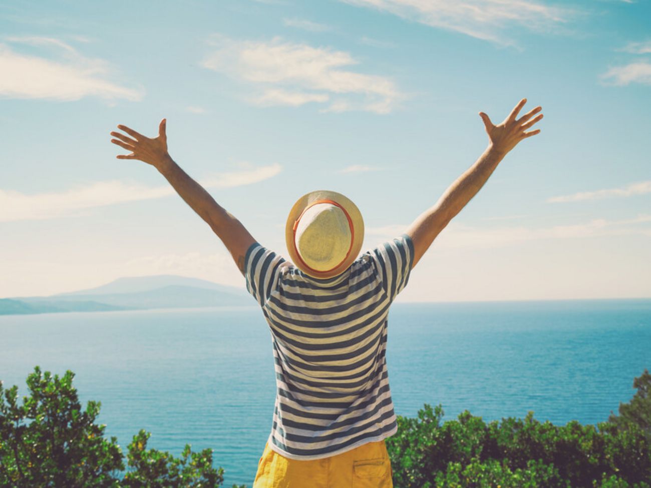 Mann streckt Arme aus an KĂĽste