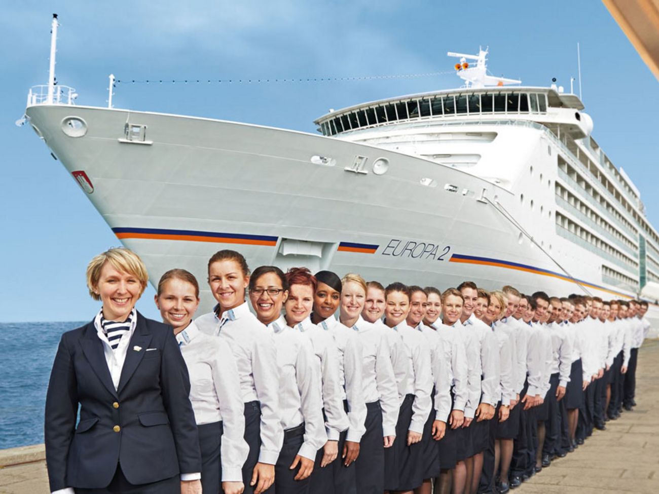 Arbeitgeber sea chefs – Karriereperspektiven (Crew): Langzeitverträge Crew der MS EUROPA 2 steht in Uniform spalier vor dem Schiff